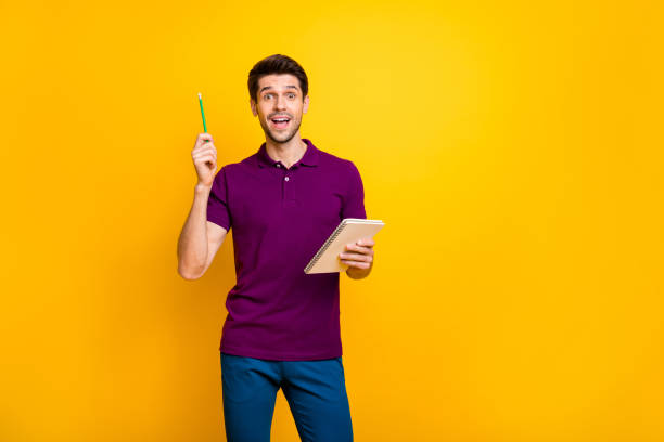 istock Portrait of his he nice attractive genius focused cheerful cheery glad guy creating making notes cool idea isolated over bright vivid shine vibrant yellow color background 1203987585