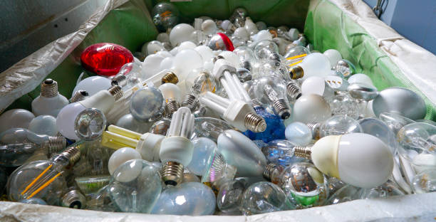 vista a fuoco selettiva di un grande cestino di riciclaggio pieno di molte lampadine di dimensioni e colori diverse - recycled bulb foto e immagini stock