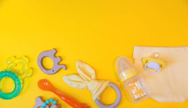istock Accessories for newborns on a yellow background. Selective focus. 1203988390