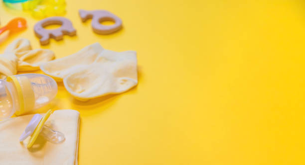 istock Accessories for newborns on a yellow background. Selective focus. 1203988406