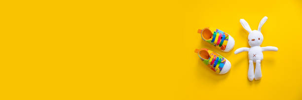 istock Shoes for newborns on a yellow background. Selective focus. 1203988515