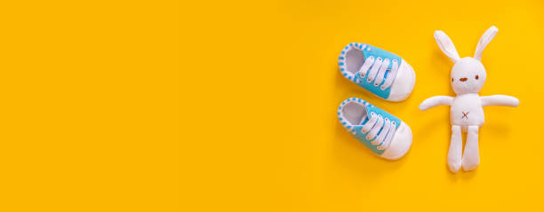 istock Shoes for newborns on a yellow background. Selective focus. 1203988545