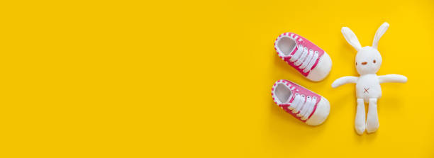 istock Shoes for newborns on a yellow background. Selective focus. 1203988582