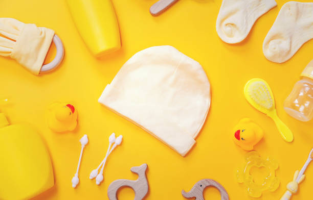 istock Accessories for newborns on a yellow background. Selective focus. 1203988775