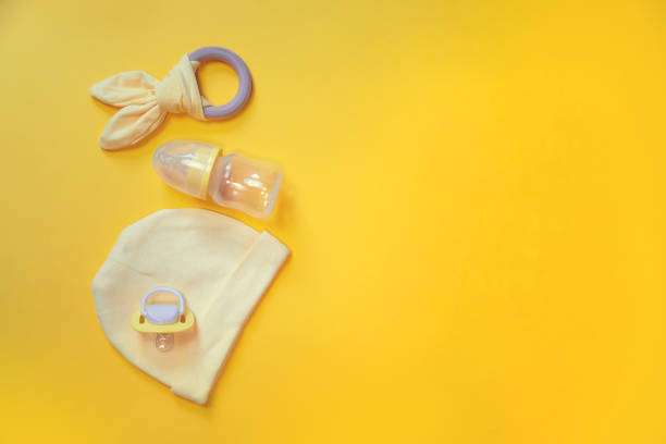 istock Accessories for newborns on a yellow background. Selective focus. 1203988837