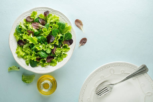 Healthy Green salad meal with fresh vegetables on blue table background