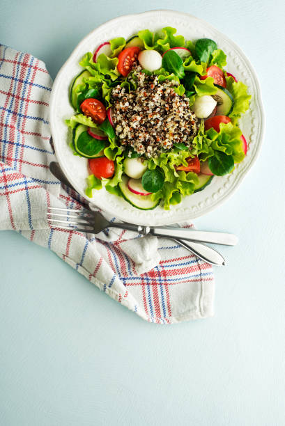 istock Salad meal with fresh vegetables and quinoa seeds 1203988841