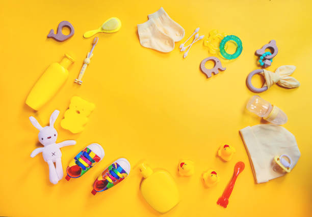 istock Accessories for newborns on a yellow background. Selective focus. 1203988858