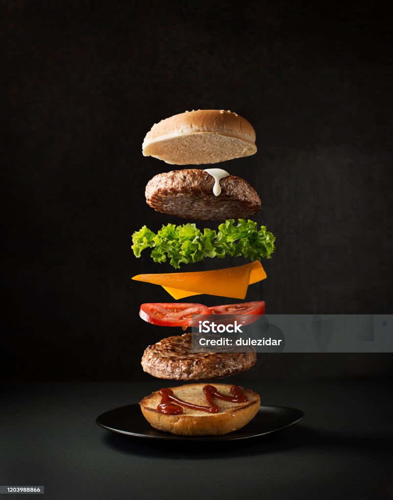 Hamburger avec des ingrédients volants - Photo de Burger libre de droits