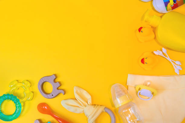 istock Accessories for newborns on a yellow background. Selective focus. 1203988877