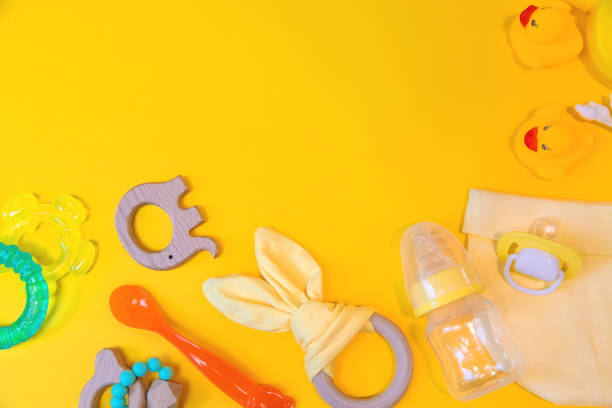 istock Accessories for newborns on a yellow background. Selective focus. 1203988894