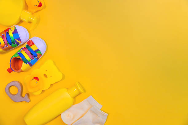istock Accessories for newborns on a yellow background. Selective focus. 1203988918