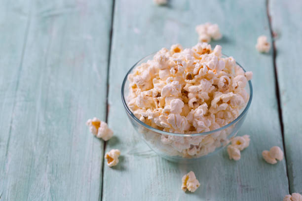istock salty popcorn on turquoise wooden surface 1203989081