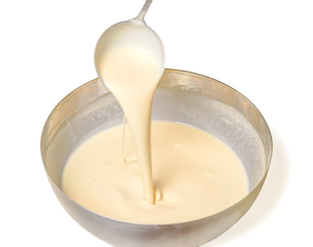 istock Kneading dough for pancakes. Batter for pancakes is poured from a large spoon 1203991914