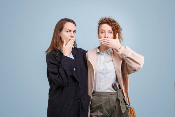 istock Embarrassed girls outrageously close their mouths 1203992058