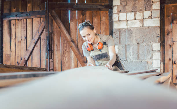 istock Woman carpenter choosing wood in storage for next project 1203993456