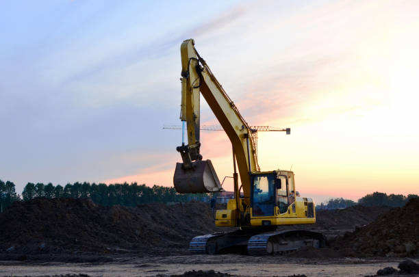a yellow excavator stands on a dirt surface