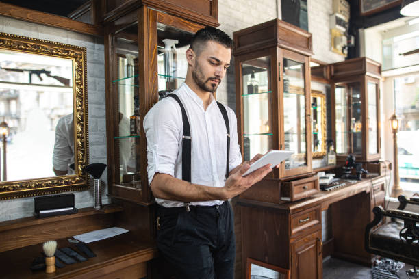 istock Professional barber shop owner using his tablet on a work breka 1203995629