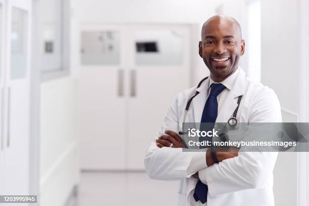 站在醫院走廊的成熟男醫生穿白色外套的肖像 照片檔及更多 醫生 照片 - 醫生, 非裔美國人種, 微笑