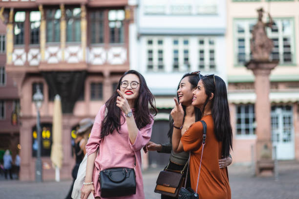 istock Joyful female tourists discussing where to head to 1203996825