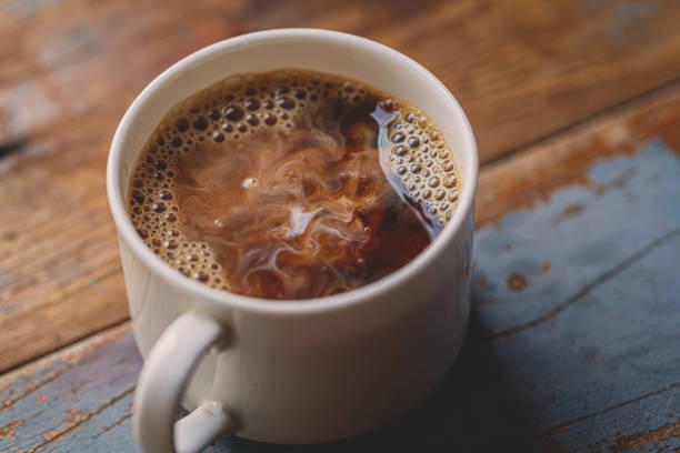 Milk Drip Into Coffee On Wood Board