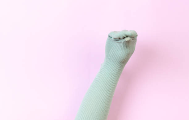 istock funny doll sock on pink background, hand theater 1203998001