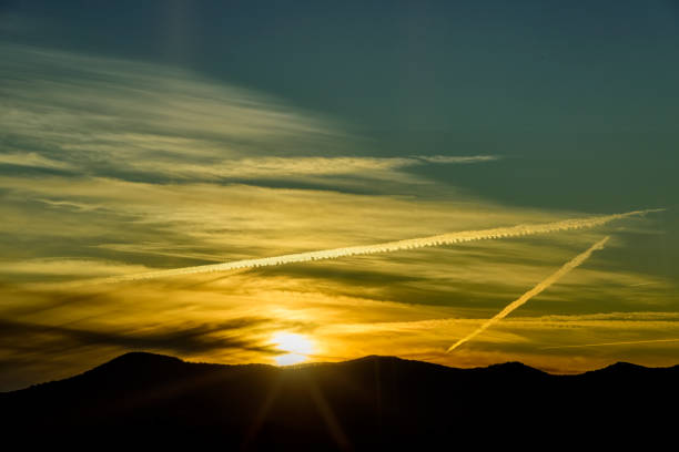 Contrail in the evening sky over the mountain silhouette in North Carolina