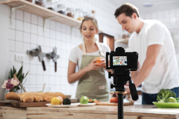 Professional digital mirrorless camera recording video blog of happy caucasian couple cooking in the kitchen room, Camera for photographer or video and live streaming concept,Vlogger and blogger. Professional digital mirrorless camera recording video blog of happy caucasian couple cooking in the kitchen room,Camera for photographer or video and live streaming concept,Vlogger and blogger. cooking show stock pictures, royalty-free photos & images