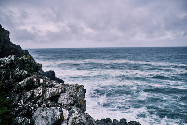Rugged rocks on the cliffs at Pentire, Newquay, Cornwall. Shallow focus, focus on the rocks, sea out of focus.