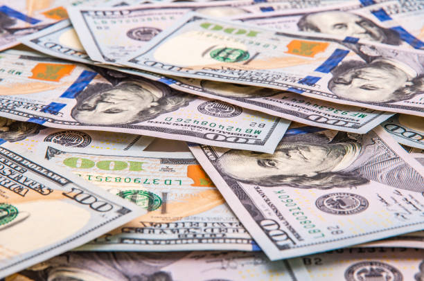 istock The background of scattered hundred dollar bills. 1204001385