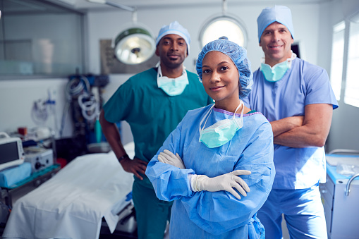 Portrait Of Multi-Cultural Surgical Team Standing In Hospital Operating Theater