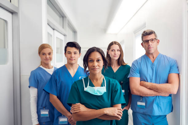 retrato del equipo médico multicultural de pie en el corredor del hospital - medical occupation uniform surgeon indoors fotografías e imágenes de stock
