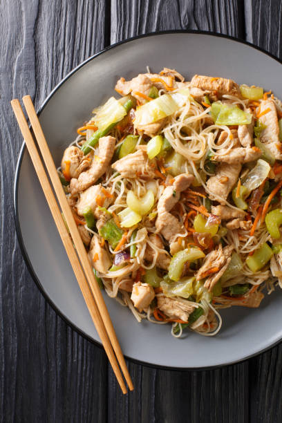 istock Pancit Bihon Filipino Fried Rice Noodles is a classic  dish that is easy to make with simple ingredients close-up in a plate. Vertical top view 1204001632