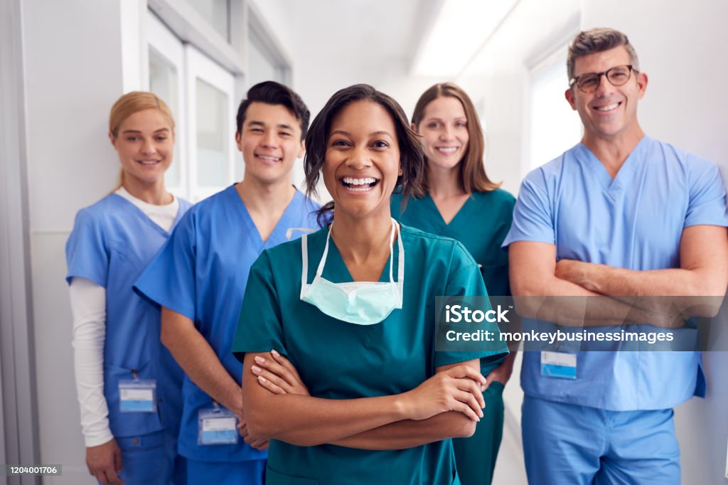 Porträt des lachenden multikulturellen medizinischen Teams, das im Krankenhauskorridor steht - Lizenzfrei Krankenpflegepersonal Stock-Foto