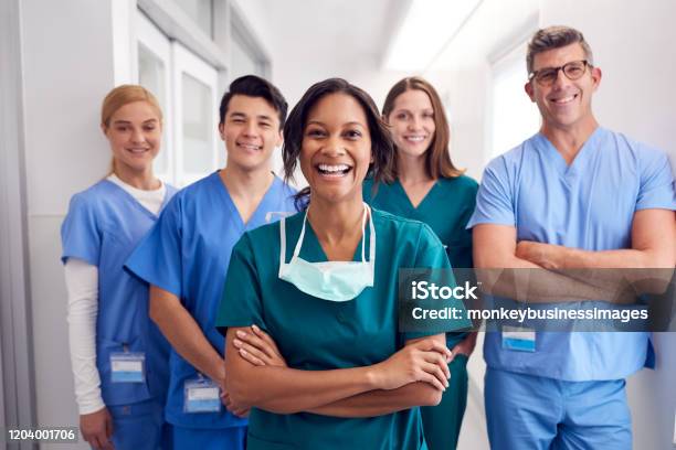 Porträt Des Lachenden Multikulturellen Medizinischen Teams Das Im Krankenhauskorridor Steht Stockfoto und mehr Bilder von Krankenpflegepersonal