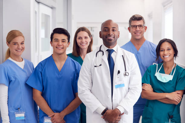 Portrait Of Multi-Cultural Medical Team Standing In Hospital Corridor Portrait Of Multi-Cultural Medical Team Standing In Hospital Corridor multi stock pictures, royalty-free photos & images