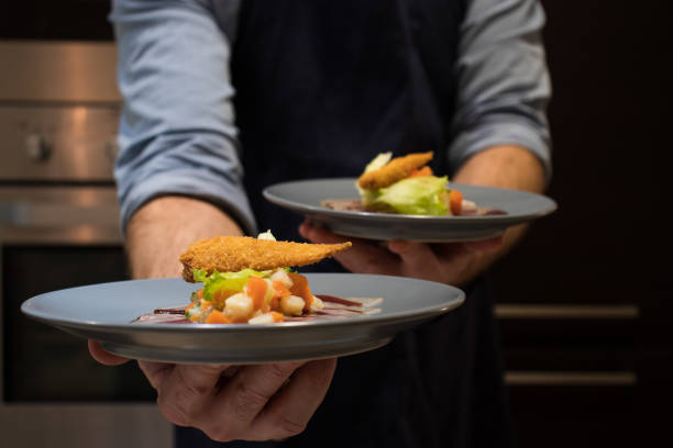 koch hält eine kulinarische vorspeise auf einem teller in der küche. ente weiße vegatables - inselrepublik malta stock-fotos und bilder