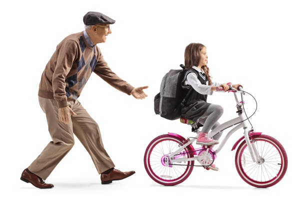 istock Grandfather teaching a girl to ride a bicycle 1204003401