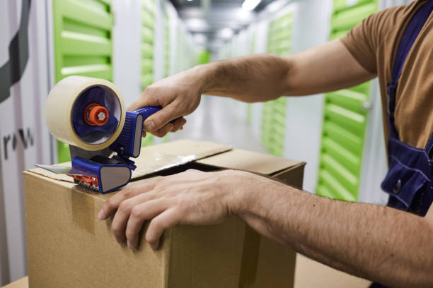 istock Man sealing the box with tape 1204003415