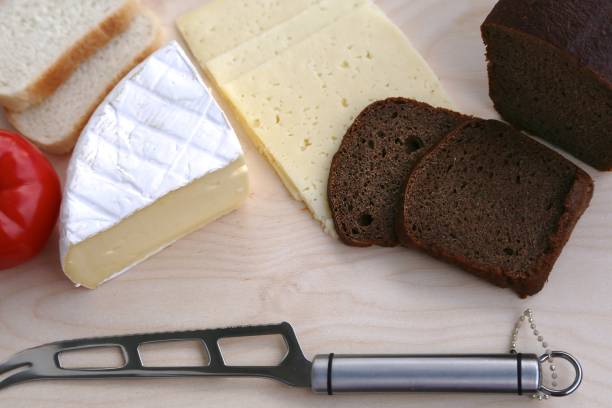 istock White and black bread, different varieties of cheese and knife view from above 1204003639