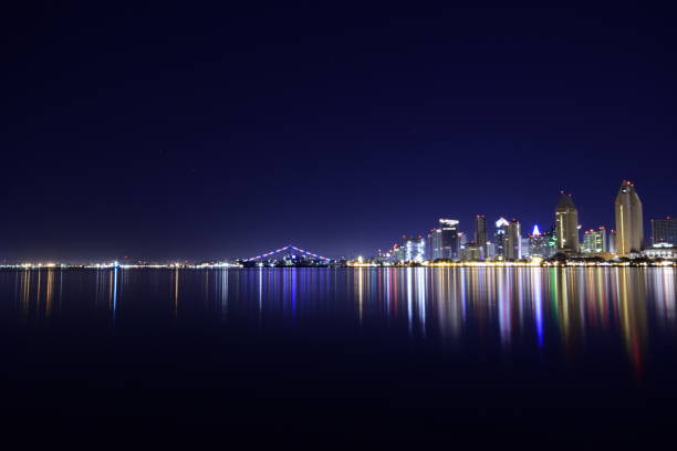 beautifully illuminated san diego urban skyline from san diego bay against clear night sky - san diego california san diego bay fun bay imagens e fotografias de stock