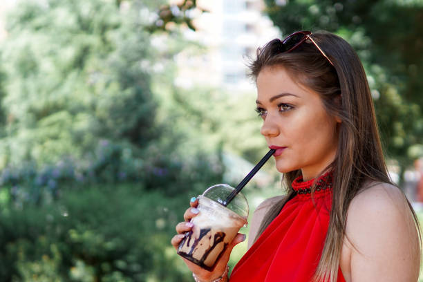 istock Woman drinking iced coffee, iced mocha with straw 1204005096