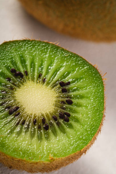 istock Kiwi fruits half sliced on vibrant plain white background, copy space, macro 1204006447