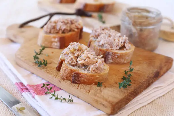 French rillettes: meat pate with bread on cutting wooden board