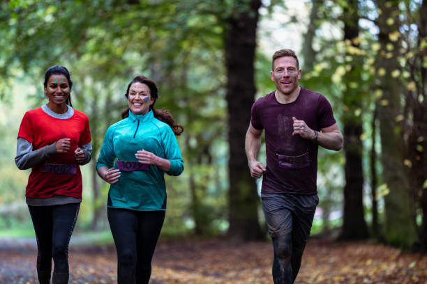 Three friends jogging together in country park