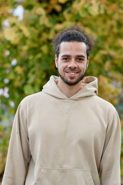 istock Cheerful hipster man smiling at camera in park 1204007158