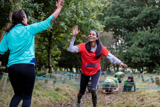 istock Woman giving friend high-five after completing obstacle course 1204008108