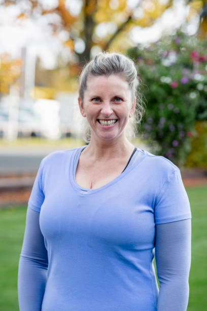 istock Confident mature woman smiling at camera in park 1204008333