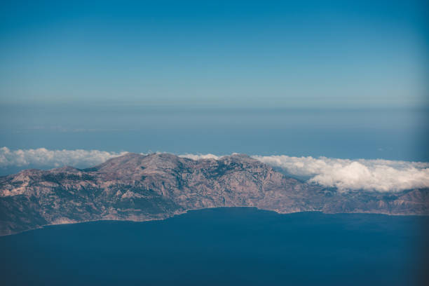 Aerial view over Karpathos island, Greece. Karpathos also Carpathos, is the second largest of the Greek Dodecanese islands, in the southeastern Aegean Sea. Together with the neighboring smaller Saria Island it forms the municipality of Karpathos, which is part of the Karpathos regional unit. Because of its remote location, Karpathos has preserved many peculiarities of dress, customs and dialect, the last resembling those of Crete and Cyprus. The island has also been called Carpathus in Latin and Scarpanto in Italian.