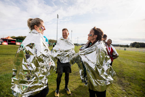 istock Athletes wrapped in foil blankets talking on sports field 1204008510